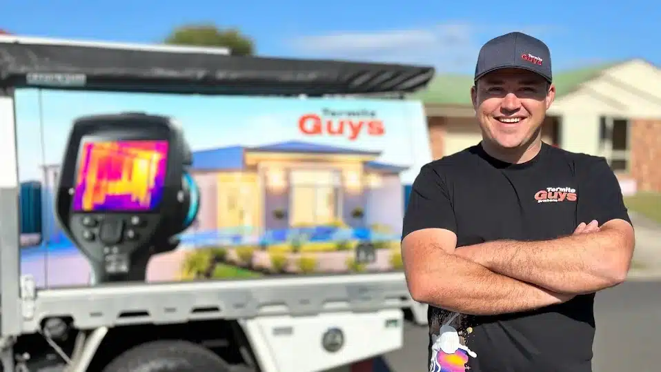 Michael Brewer, director of Termite Guys Brisbane, standing in front of a company vehicle with thermal imaging camera signage.